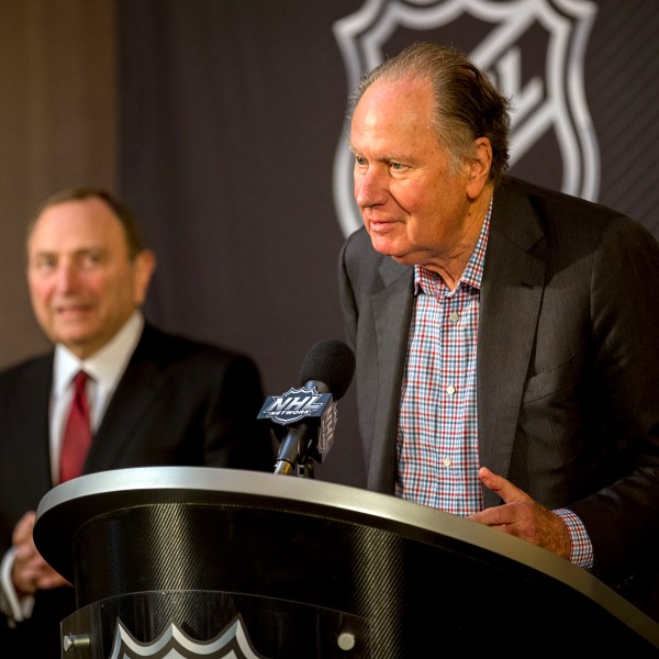 FILE - Seattle Kraken founding owner David Bonderman, right, steps up to the podium after the National Hockey League Commissioner Gary Bettman, left, named Seattle as the league's 32nd franchise, Dec. 4, 2018, in Sea Island, Ga. (AP Photo/Stephen B. Morton, File)