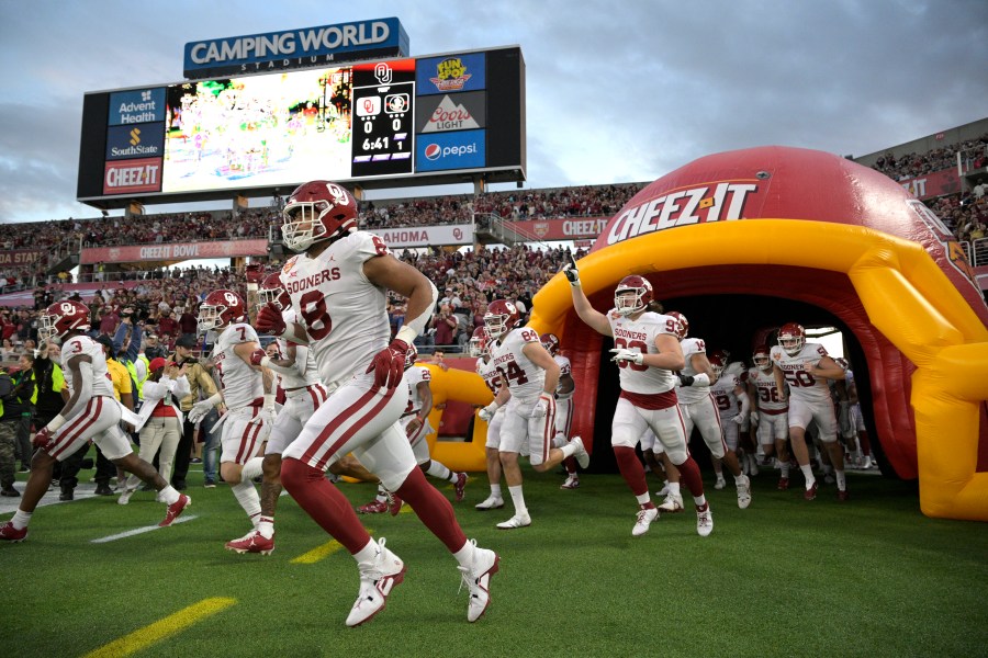 FILE - Oklahoma players run onto the field before the Cheez-It Bowl NCAA college football game against Florida State, Thursday, Dec. 29, 2022, in Orlando, Fla. (AP Photo/Phelan M. Ebenhack, File)