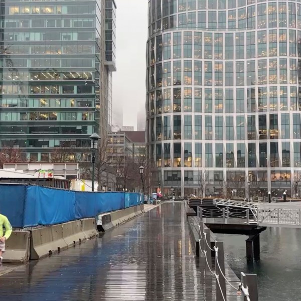 A jogger runs along the harbor as rain falls in Boston’s Seaport neighborhood on Wednesday Dec 11, 2024. (AP Photo/Michael Casey)