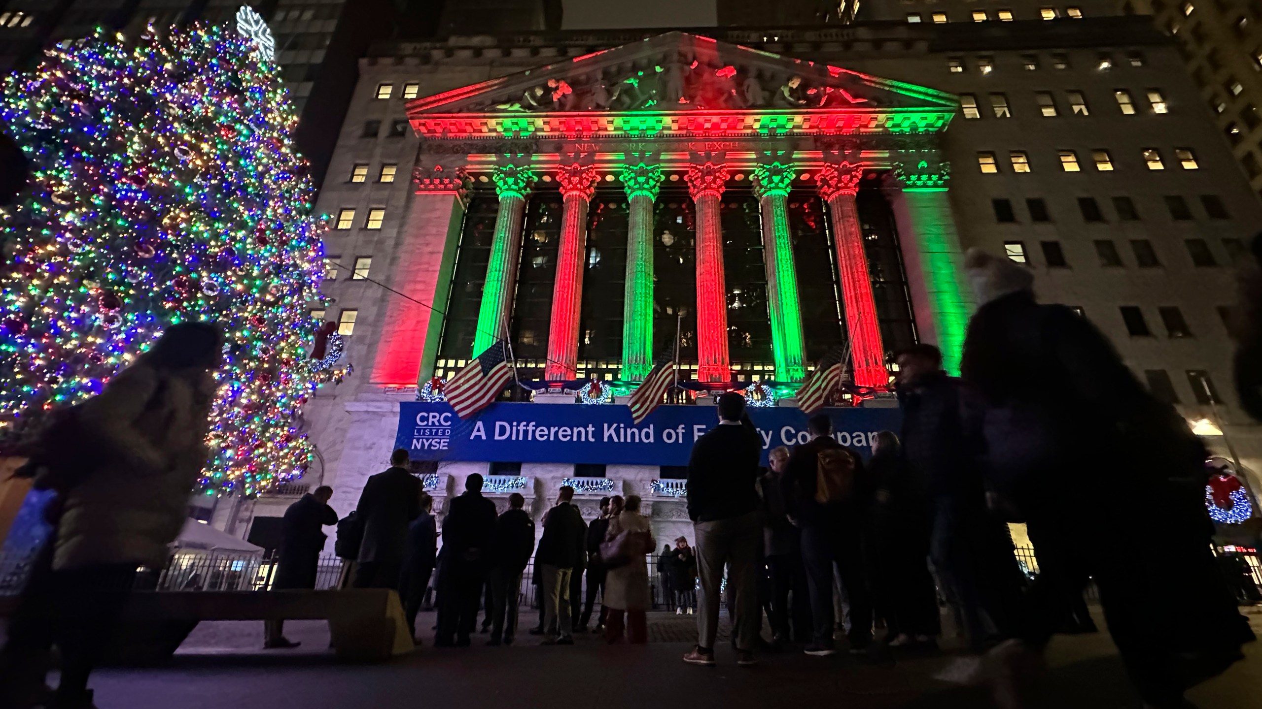 People gather in front of the New York Stock Exchange in New York's Financial District on Tuesday, Dec. 10, 2024. (AP Photo/Peter Morgan)