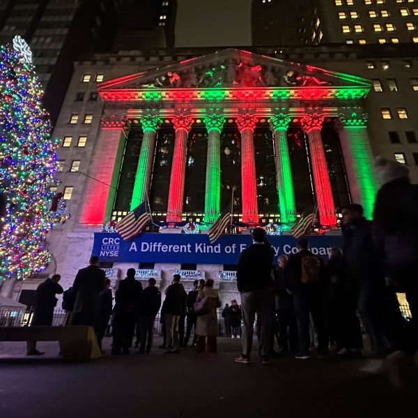 People gather in front of the New York Stock Exchange in New York's Financial District on Tuesday, Dec. 10, 2024. (AP Photo/Peter Morgan)