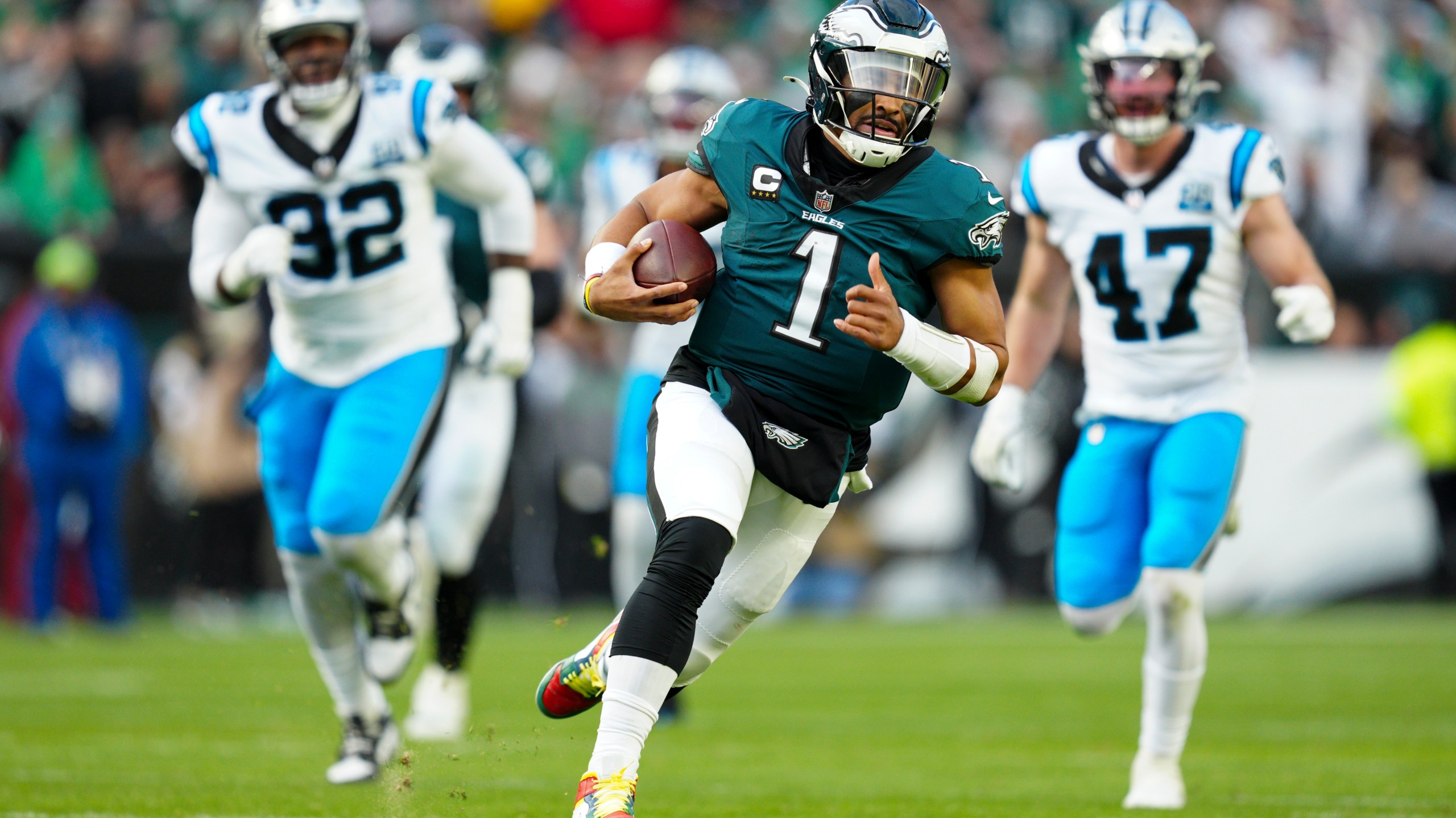 Philadelphia Eagles quarterback Jalen Hurts (1) runs with the ball as Carolina Panthers cornerback Lonnie Johnson Jr. (32) and linebacker Josey Jewell (47) trail behind during the second half of an NFL football game Sunday, Dec. 8, 2024, in Philadelphia. (AP Photo/Derik Hamilton)