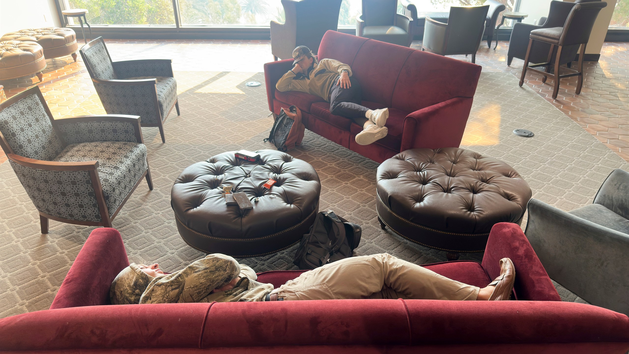 Students sleep on couches on the Pepperdine University campus, where a makeshift shelter was set up as the Franklin Fire closed in Tuesday, Dec. 10, 2024, in Malibu, Calif. (AP Photo/Damian Dovarganes)