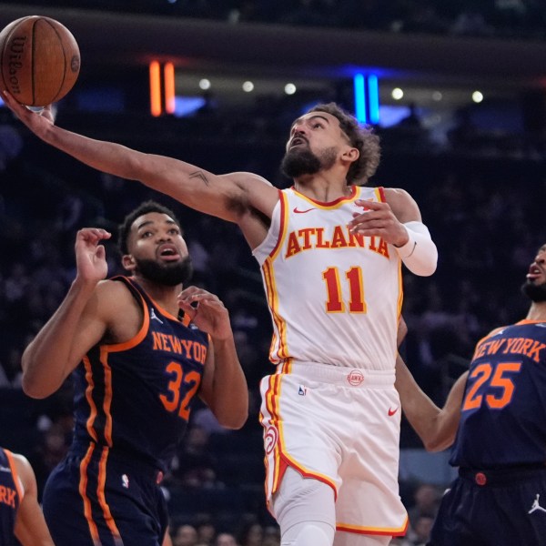 Atlanta Hawks' Trae Young (11) drives past New York Knicks' Mikal Bridges (25), Karl-Anthony Towns (32) and Josh Hart (3) during the first half of an Emirates NBA Cup basketball game Wednesday, Dec. 11, 2024, in New York. (AP Photo/Frank Franklin II)