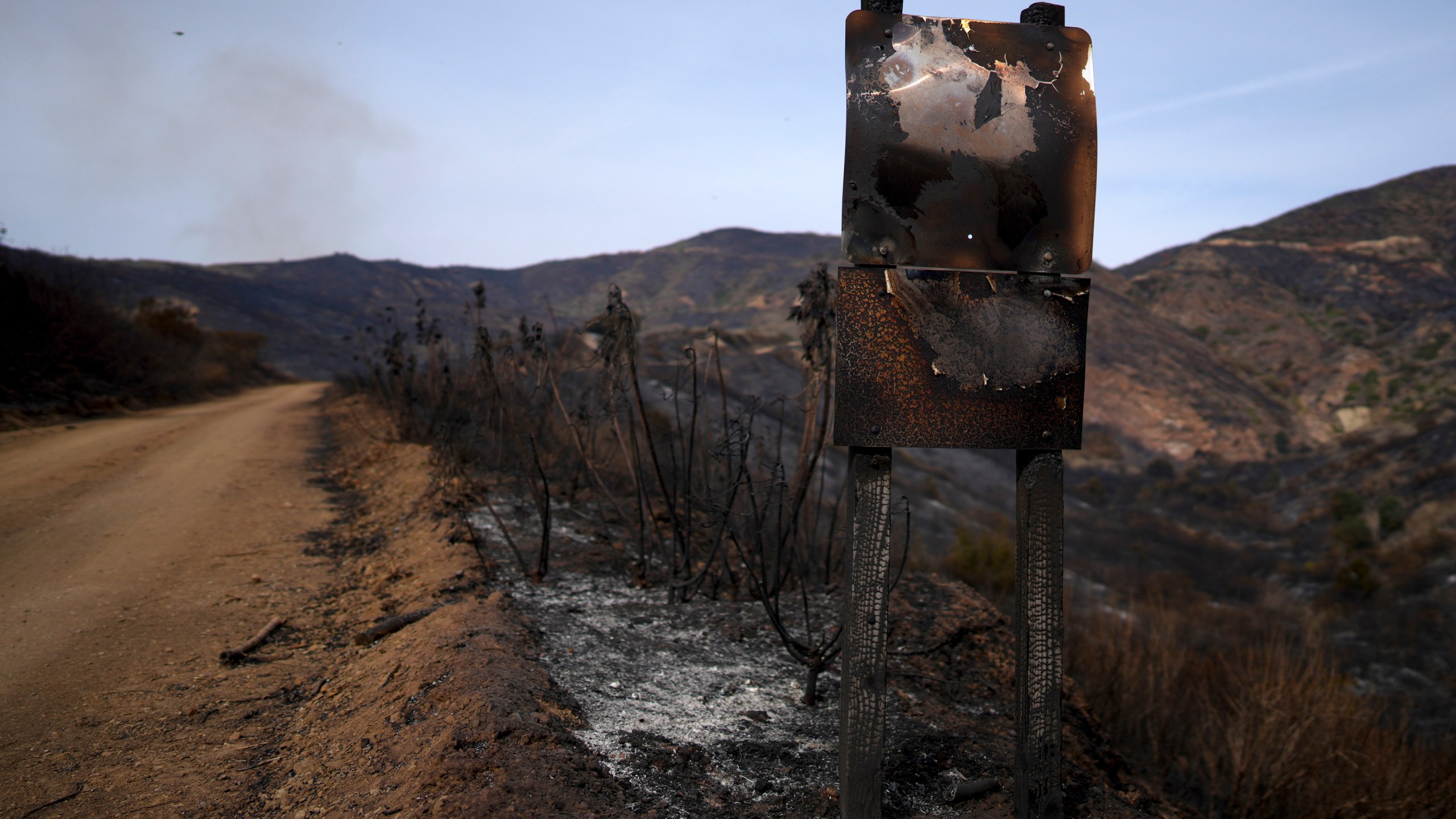 A road signed is burned after the Franklin Fire swept through Wednesday, Dec. 11, 2024, in Malibu, Calif. (AP Photo/Eric Thayer)