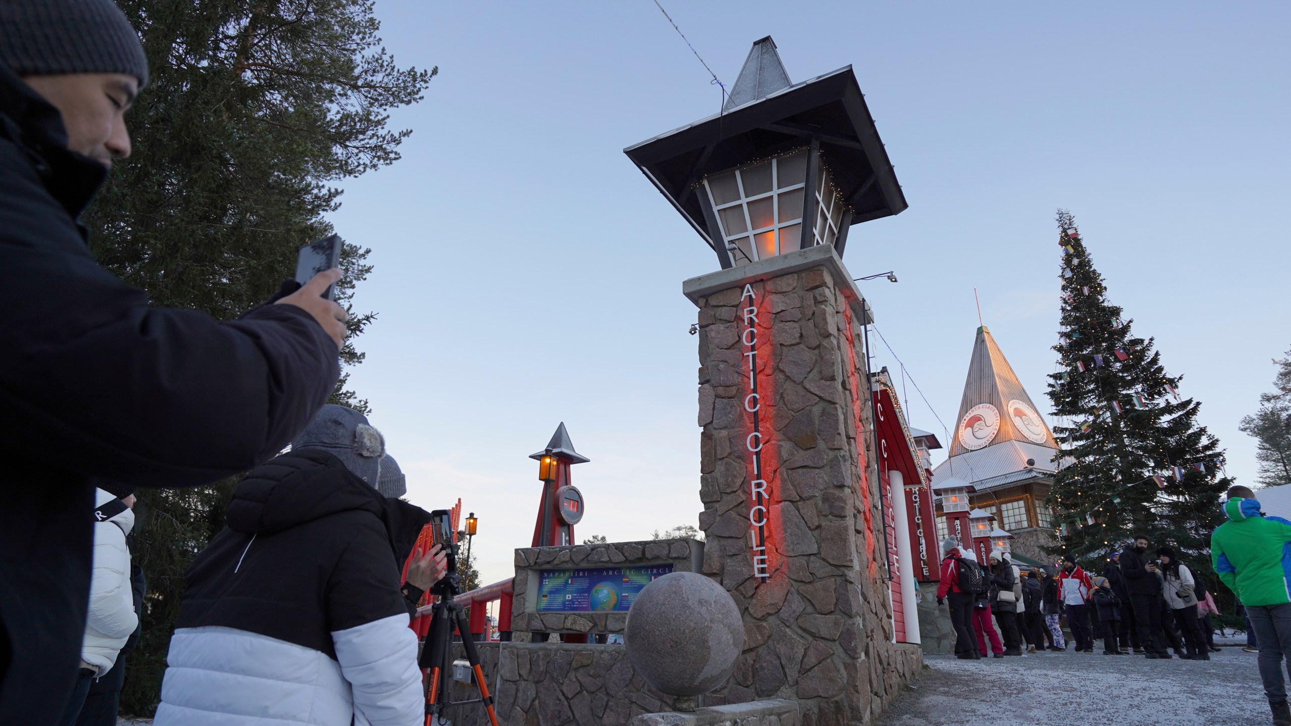 Tourists visit Santa Claus Village, a winter-themed amusement park perched on the edge of the Arctic Circle, in Rovaniemi, Finland, Wednesday, Dec. 4, 2024. (AP Photo/James Brooks)