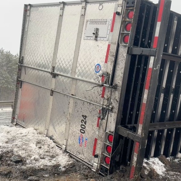 A tractor-trailer hauling a load of oranges sits on the side of the road after sliding off the Maine Turnpike early on Wednesday, Dec. 11, 2024, in New Gloucester, Maine. (AP Photo/David Sharp)