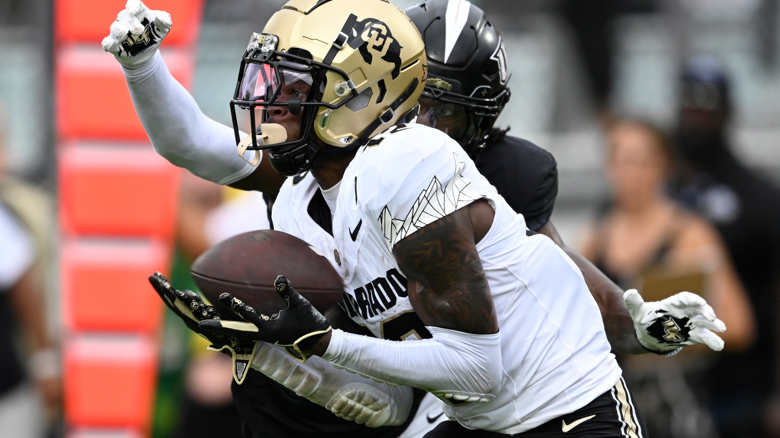 FILE - Colorado wide receiver Travis Hunter (12) catches a pass in the end zone for a 23-yard touchdown reception ahead of Central Florida defensive back Brandon Adams during the first half of an NCAA college football game, Saturday, Sept. 28, 2024, in Orlando, Fla. (AP Photo/Phelan M. Ebenhack, File)