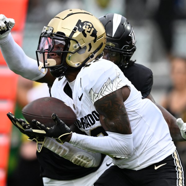 FILE - Colorado wide receiver Travis Hunter (12) catches a pass in the end zone for a 23-yard touchdown reception ahead of Central Florida defensive back Brandon Adams during the first half of an NCAA college football game, Saturday, Sept. 28, 2024, in Orlando, Fla. (AP Photo/Phelan M. Ebenhack, File)