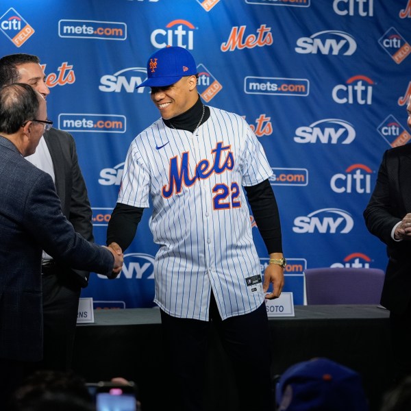 New York Mets owner Steven Cohen, left, shakes hands with Juan Soto, center, as sports agent Scott Boras, right and Mets president of baseball operations David Stearns, look on during a news conference, Thursday, Dec. 12, 2024, in New York. (AP Photo/Frank Franklin II)