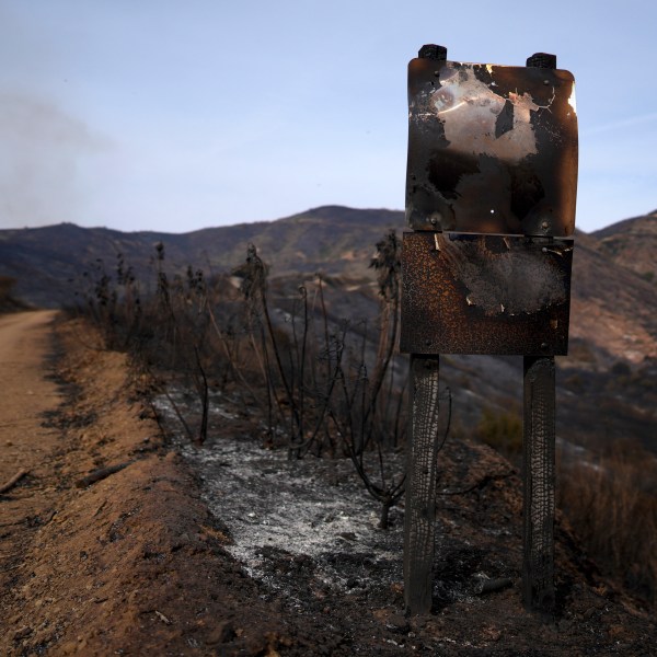 A road signed is burned after the Franklin Fire swept through Wednesday, Dec. 11, 2024, in Malibu, Calif. (AP Photo/Eric Thayer)