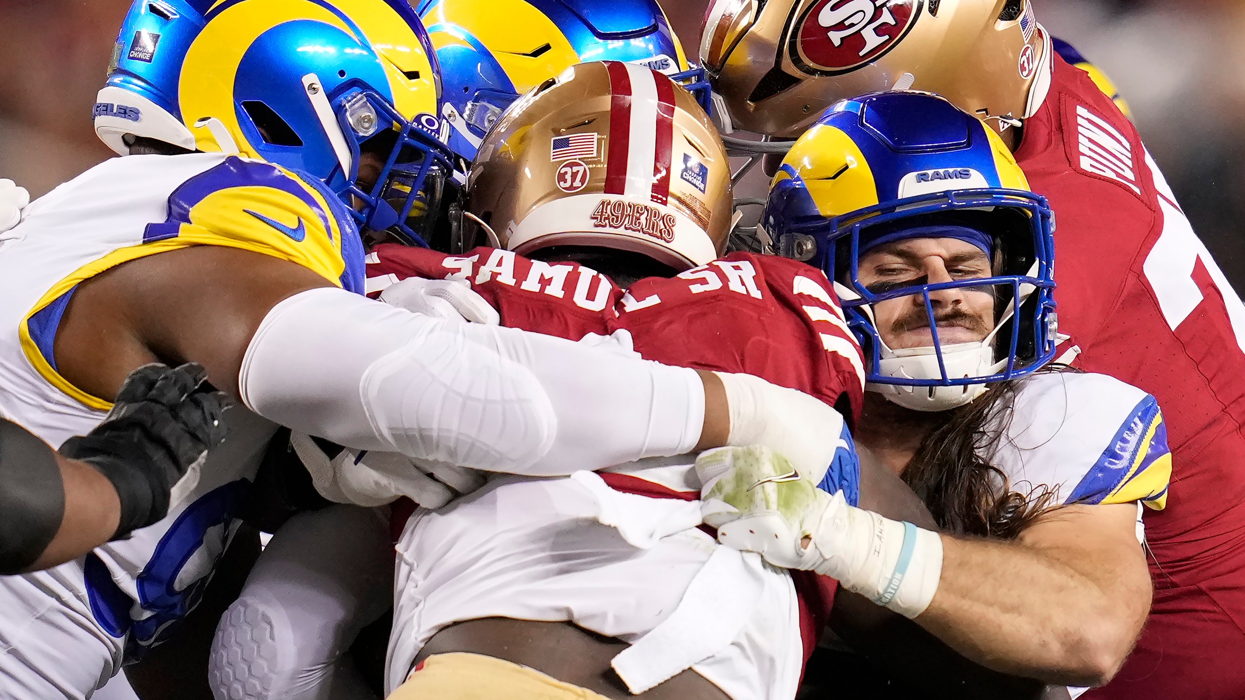 San Francisco 49ers wide receiver Deebo Samuel Sr., center, is tackled by Los Angeles Rams linebacker Christian Rozeboom, front right, and others during the first half of an NFL football game in Santa Clara, Calif., Thursday, Dec. 12, 2024. (AP Photo/Godofredo A. Vásquez)