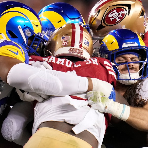 San Francisco 49ers wide receiver Deebo Samuel Sr., center, is tackled by Los Angeles Rams linebacker Christian Rozeboom, front right, and others during the first half of an NFL football game in Santa Clara, Calif., Thursday, Dec. 12, 2024. (AP Photo/Godofredo A. Vásquez)