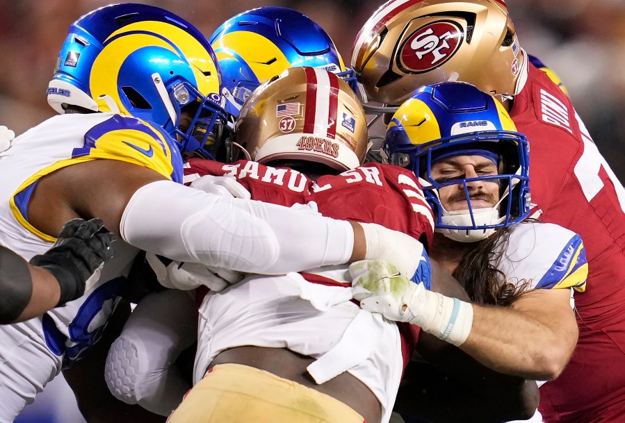 San Francisco 49ers wide receiver Deebo Samuel Sr., center, is tackled by Los Angeles Rams linebacker Christian Rozeboom, front right, and others during the first half of an NFL football game in Santa Clara, Calif., Thursday, Dec. 12, 2024. (AP Photo/Godofredo A. Vásquez)