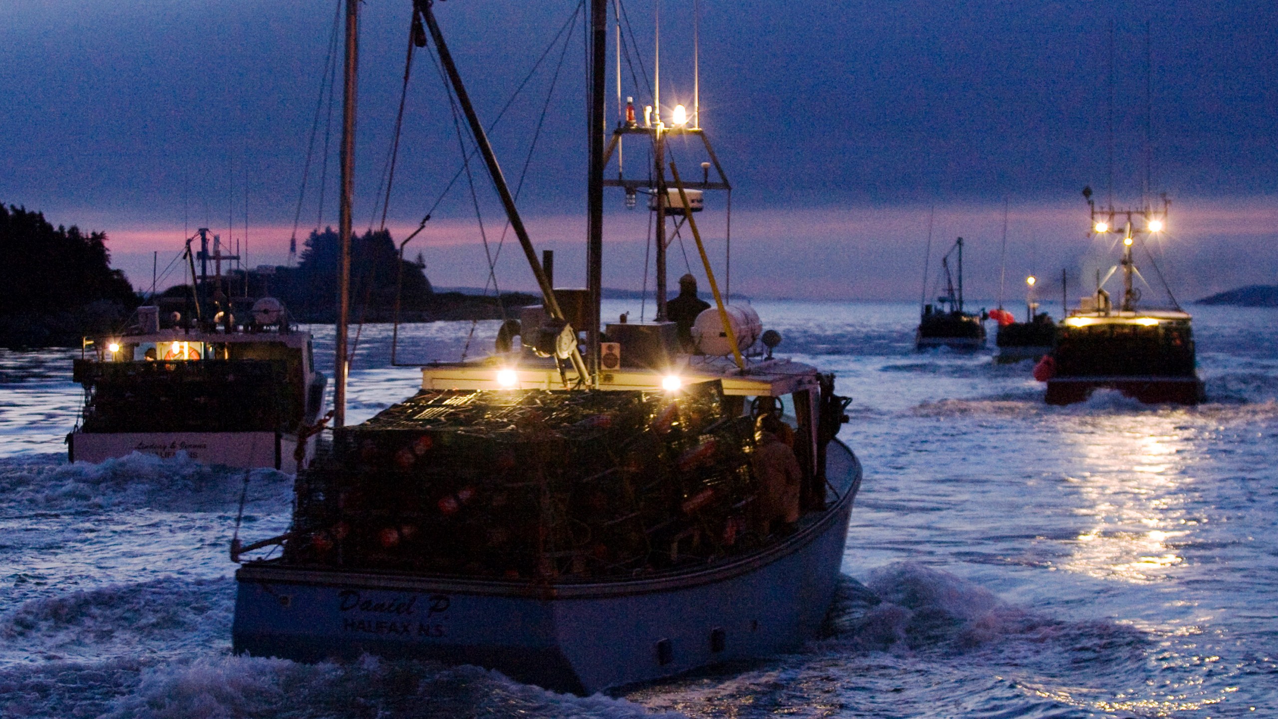 FILE — Fishing boats carrying lobster traps leave the harbor in West Dover Nova Scotia, Nov. 30, 2009. (AP Photo/The Canadian Press, Andrew Vaughan, File)