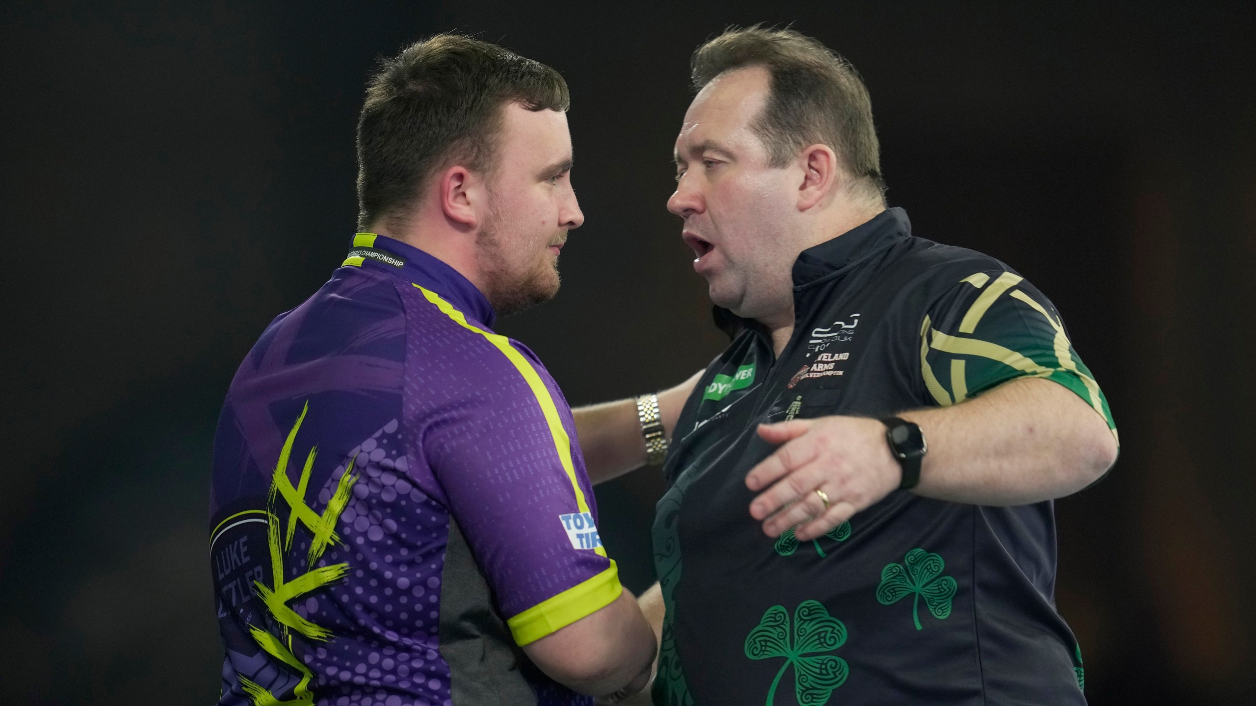 FILE - Luke Littler of England, left, shakes hands with Brendan Dolan of Northern Ireland after winning the quarterfinal match at the World Darts Championship, in London, Monday, Jan. 1, 2024. (AP Photo/Kin Cheung, File)