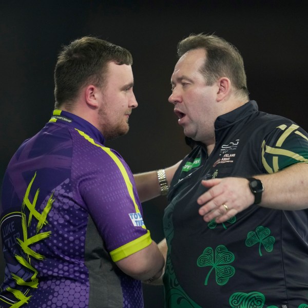 FILE - Luke Littler of England, left, shakes hands with Brendan Dolan of Northern Ireland after winning the quarterfinal match at the World Darts Championship, in London, Monday, Jan. 1, 2024. (AP Photo/Kin Cheung, File)