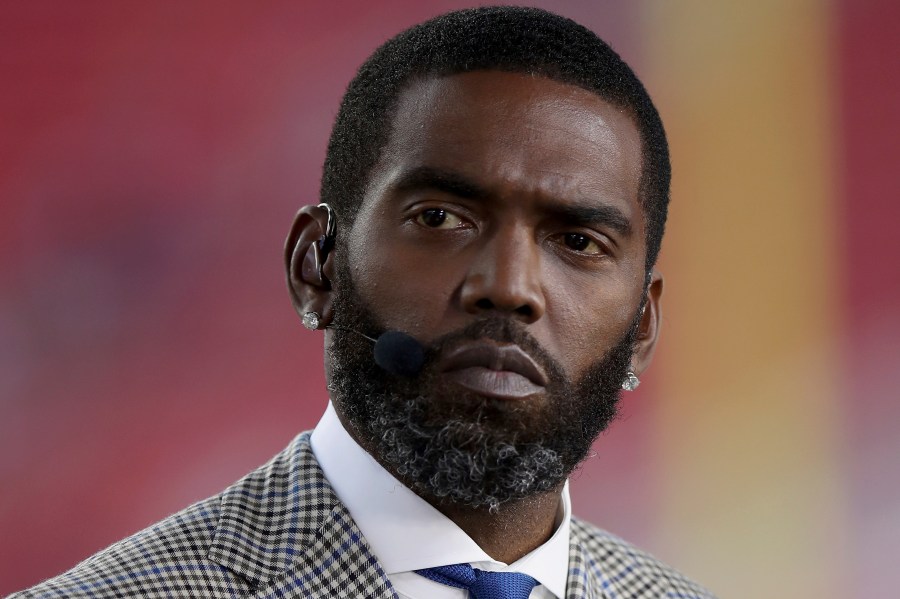 FILE - Broadcaster Randy Moss sits on the sideline before an NFL football game between the San Francisco 49ers and the Los Angeles Rams, Monday, Nov. 15, 2021, in Santa Clara, Calif. (AP Photo/Scot Tucker, File)