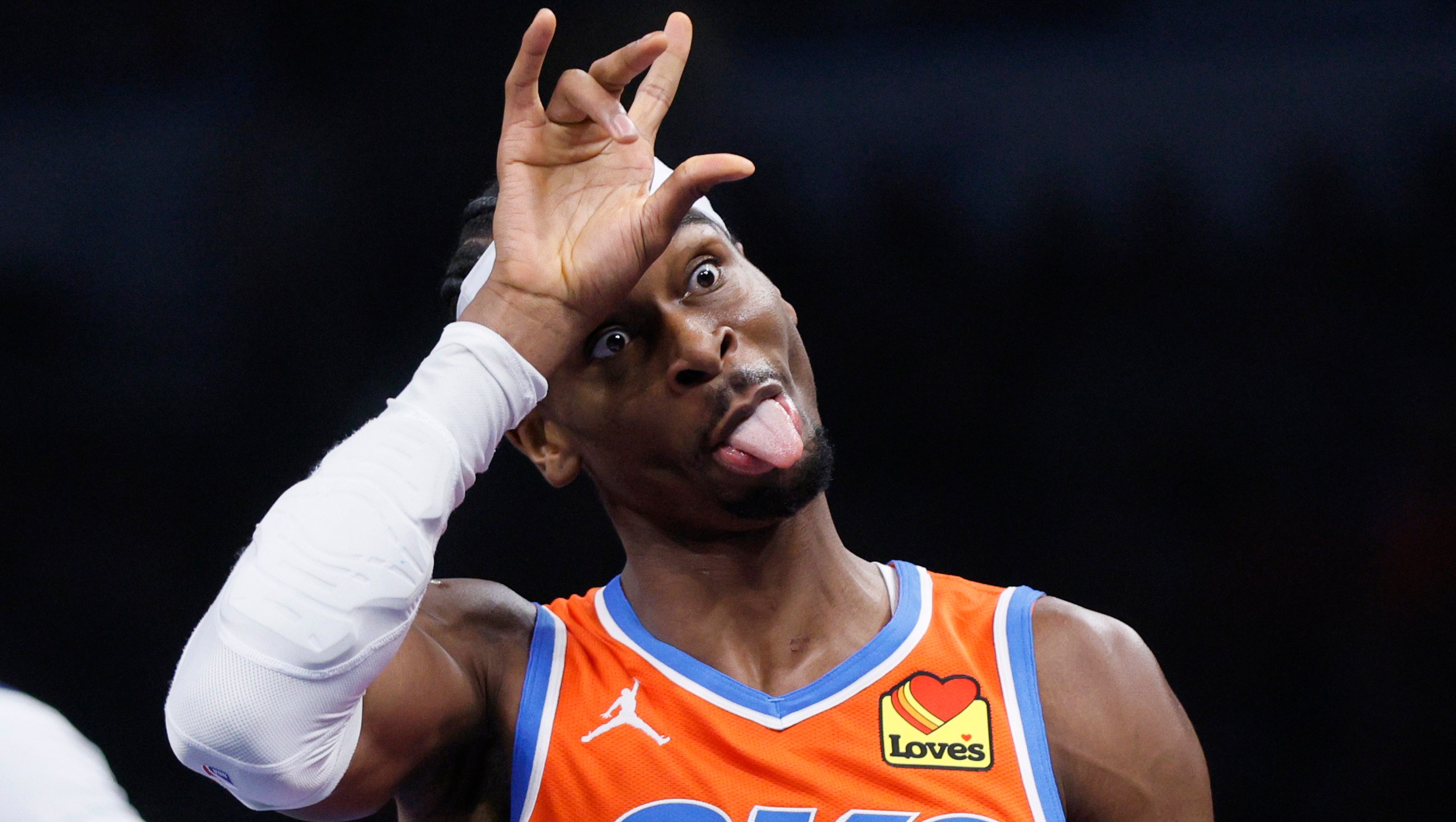 Oklahoma City Thunder guard Shai Gilgeous-Alexander (2) sticks his tongue out while celebrating a 3-pointer during the first half of an Emirates NBA Cup basketball game against the Dallas Mavericks, Tuesday, Dec. 10, 2024, in Oklahoma City. (AP Photo/Nate Billings)