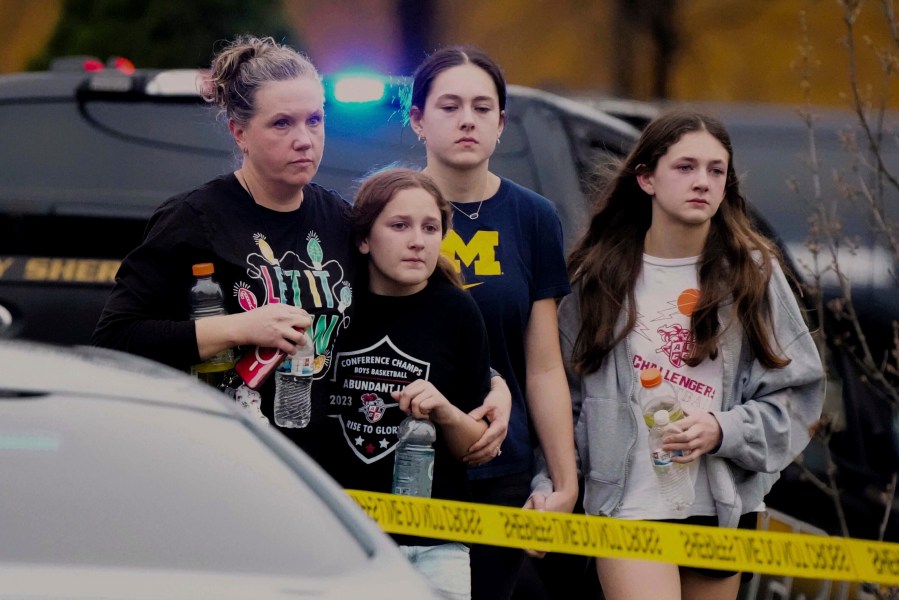 A family leaves the shelter after multiple injuries were reported following a shooting at the Abundant Life Christian School, Monday, Dec. 16, 2024. (AP Photo/Morry Gash)