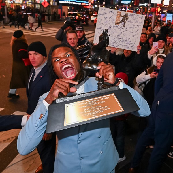 Travis Hunter poses in Times Square with the Heisman Trophy after winning it as the outstanding player in college football Saturday, Dec. 14, 2024, in New York. (Todd Van Emst/Heisman Trust via AP, Pool)