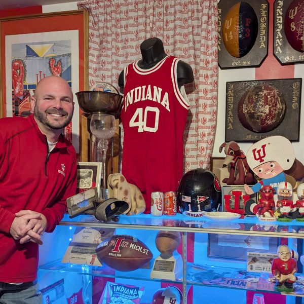 In this photo provided by Heather White, Indiana Hoosiers fan Brett White pose Monday, Dec. 16, 2024, at his home in Bloomington, Ind. White and other Indiana fans are riding the euphoria of a great season that culminated in a berth in the College Football Playoff. The Hoosiers will meet Notre Dame on Friday night in South Bend, Ind. (Heather White via AP)