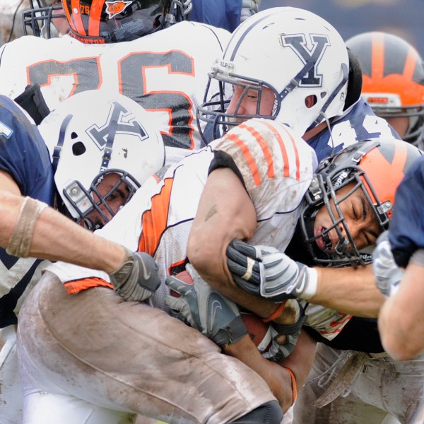 FILE - Princeton's Jordan Culbreath, center, fights for an extra yard as he is tackled by Yale's Jay Pilkerton, left, Bobby Abare, center, and Brady Hart, right during Yale's 14-0 victory in an NCAA college football game in New Haven, Conn., on Saturday, Nov. 15, 2008. (AP Photo/Fred Beckham, File)