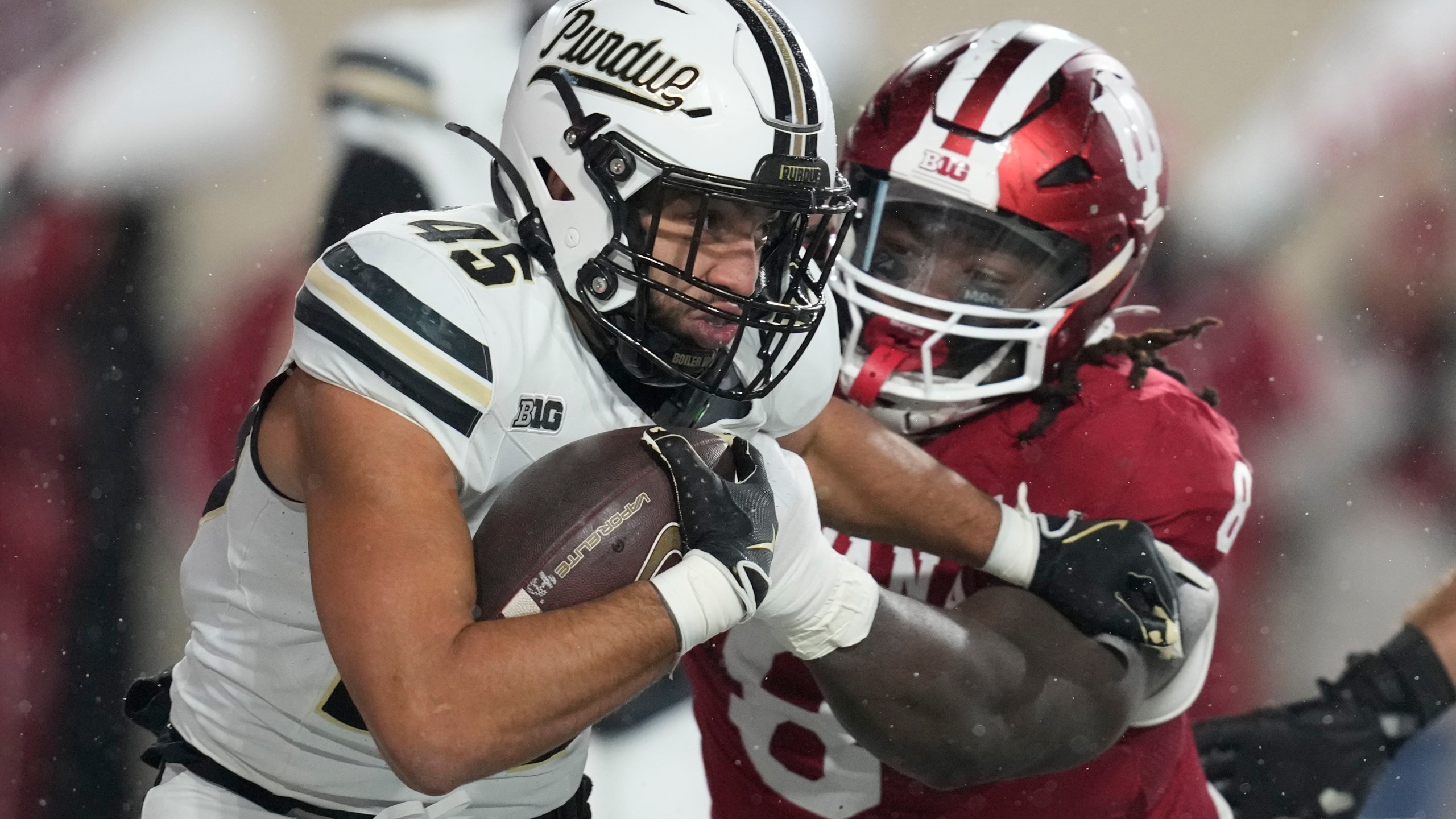 Purdue running back Devin Mockobee (45) runs out of the tackle of Indiana defensive lineman CJ West during the first half of an NCAA college football game, Saturday, Nov. 30, 2024, in Bloomington, Ind. (AP Photo/Darron Cummings)