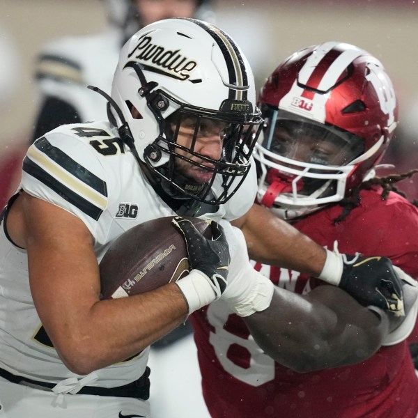 Purdue running back Devin Mockobee (45) runs out of the tackle of Indiana defensive lineman CJ West during the first half of an NCAA college football game, Saturday, Nov. 30, 2024, in Bloomington, Ind. (AP Photo/Darron Cummings)