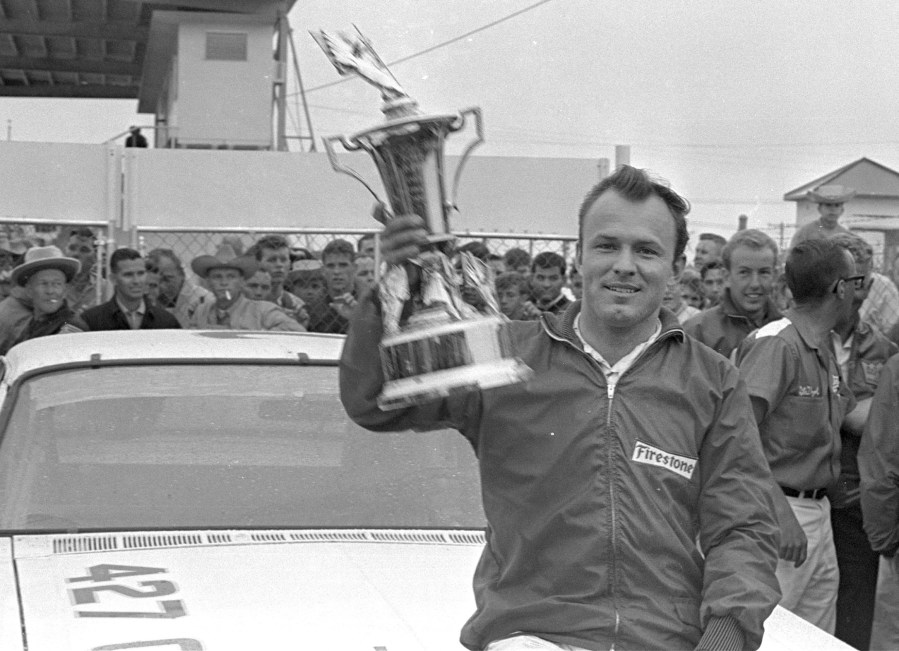 FILE - In this Feb. 14, 1965, file photo, Fred Lorenzen, of Elmhurst, Ill., gives a victory wave after winning the Daytona 500 mile stock car auto race which was halted by rain at the end of 133 laps, in Daytona Beach, Fla. (AP Photo/File)