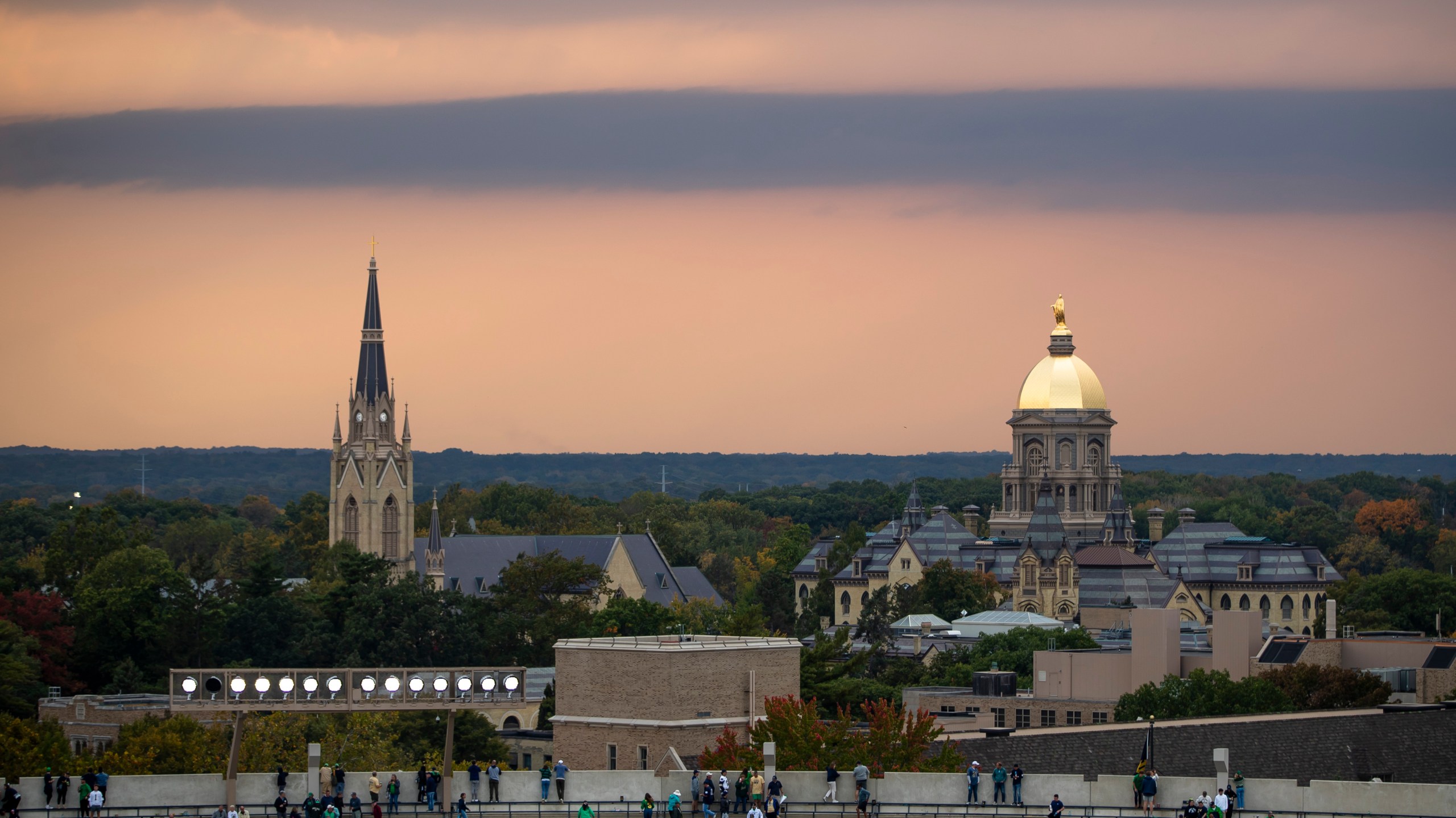 FILE - Fans file out of the stadium as clouds approach the Golden Dome and Basilica of the Sacred Heart on Oct. 12, 2024, in South Bend, Ind. (AP Photo/Michael Caterina, File)