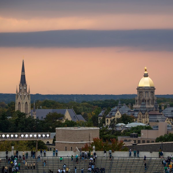 FILE - Fans file out of the stadium as clouds approach the Golden Dome and Basilica of the Sacred Heart on Oct. 12, 2024, in South Bend, Ind. (AP Photo/Michael Caterina, File)