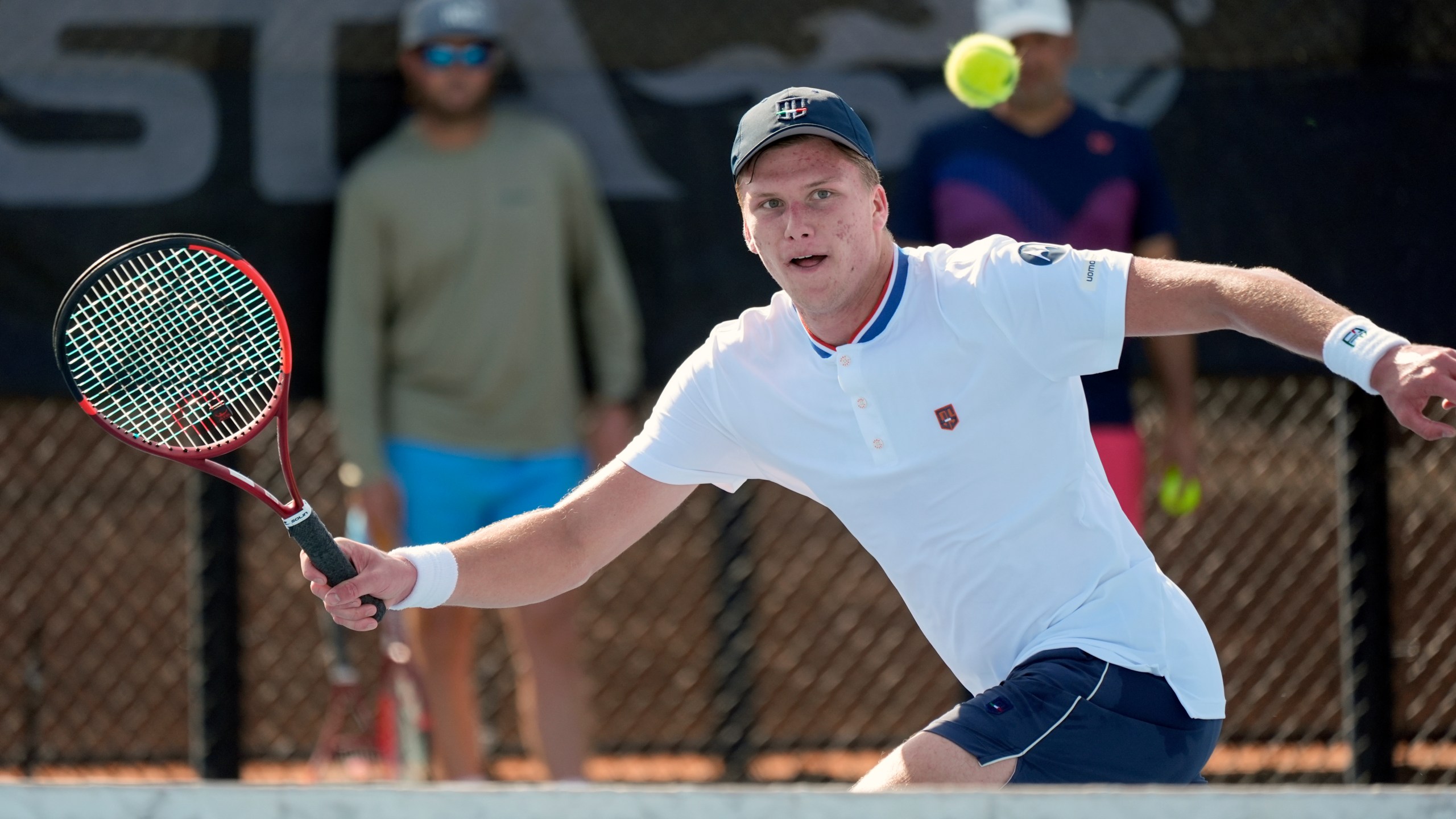 Tennis player Jenson Brooksby practices at the USTA national campus while his coaches Rhyne Williams, back left, and Eric Nunez watch, Tuesday, Dec. 10, 2024, in Orlando, Fla. (AP Photo/John Raoux)