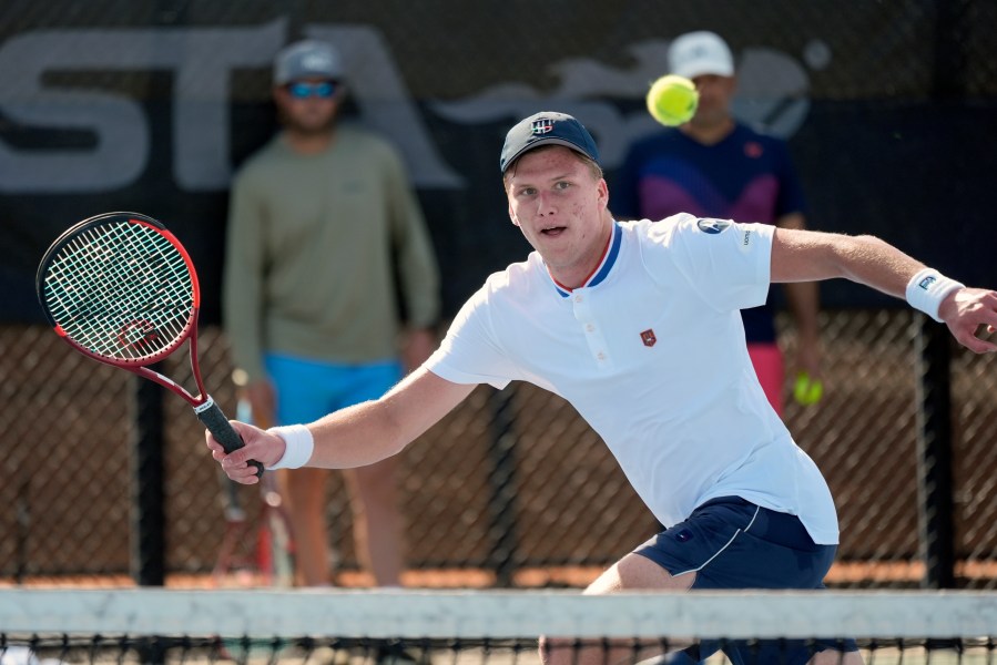 Tennis player Jenson Brooksby practices at the USTA national campus while his coaches Rhyne Williams, back left, and Eric Nunez watch, Tuesday, Dec. 10, 2024, in Orlando, Fla. (AP Photo/John Raoux)