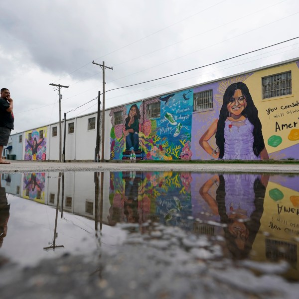 FILE - A couple visits murals created to honor the victims of the shootings at Robb Elementary School, Aug. 25, 2022, in Uvalde, Texas. (AP Photo/Eric Gay, file)