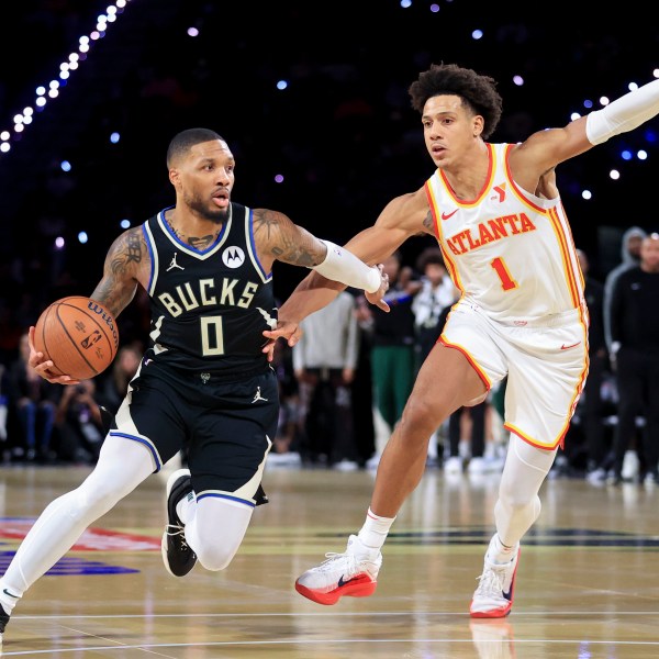 Milwaukee Bucks guard Damian Lillard (0) drives past Atlanta Hawks forward Jalen Johnson (1) during the second half of a semifinal game in the NBA Cup basketball tournament Saturday, Dec. 14, 2024, in Las Vegas. (AP Photo/Ian Maule)