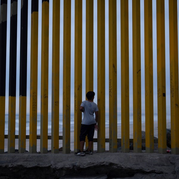 FILE - A boy looks through a border wall separating Mexico from the United States, Nov. 26, 2024, in Tijuana, Mexico. (AP Photo/Gregory Bull, File)