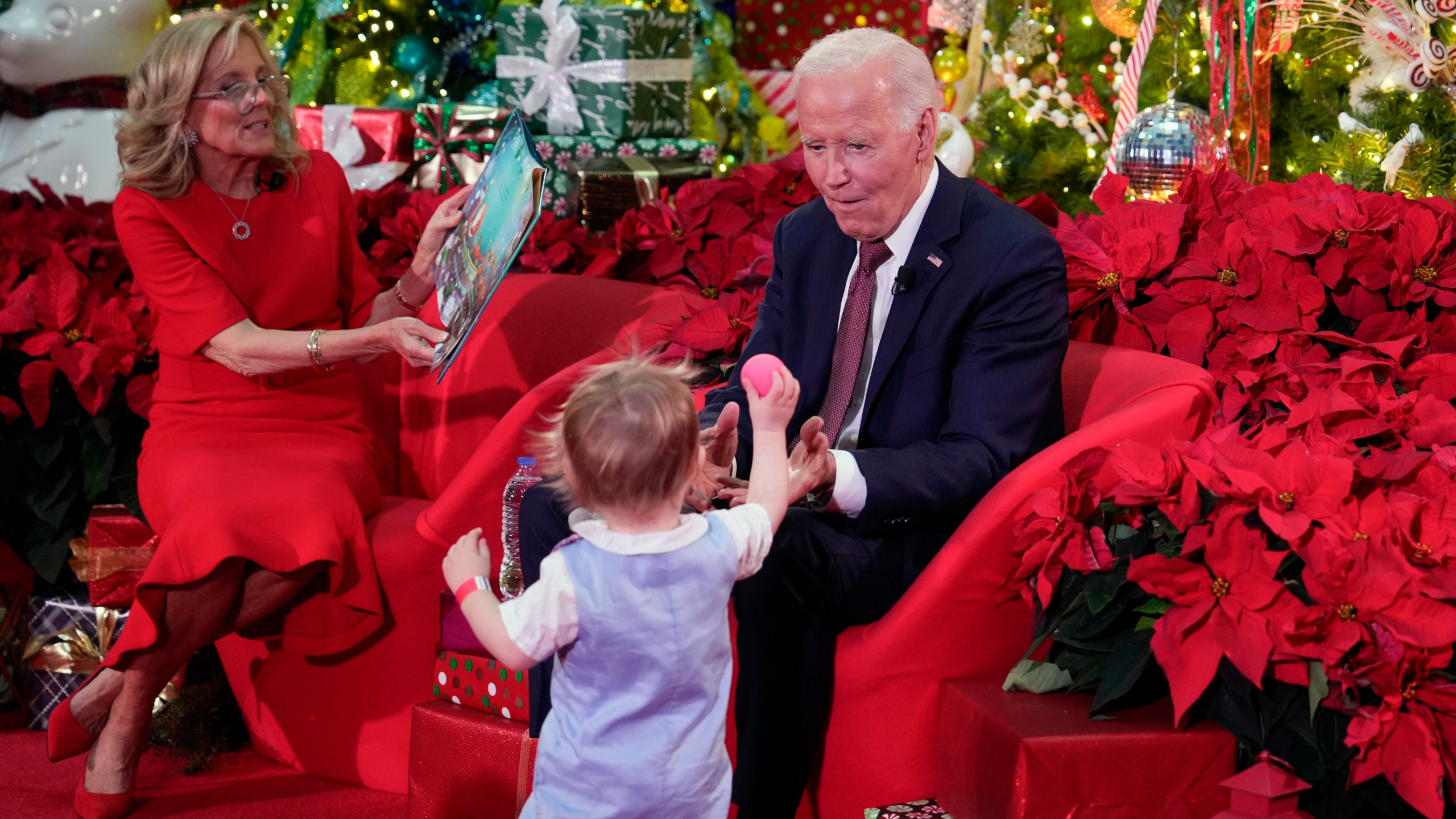 President Joe Biden and first lady Jill Biden, as she reads 'Twas the Night Before Christmas, visit patients and families at the Children's National Hospital in Washington, Friday, Dec. 20, 2024. (AP Photo/Ben Curtis)