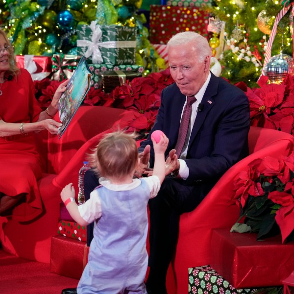 President Joe Biden and first lady Jill Biden, as she reads 'Twas the Night Before Christmas, visit patients and families at the Children's National Hospital in Washington, Friday, Dec. 20, 2024. (AP Photo/Ben Curtis)