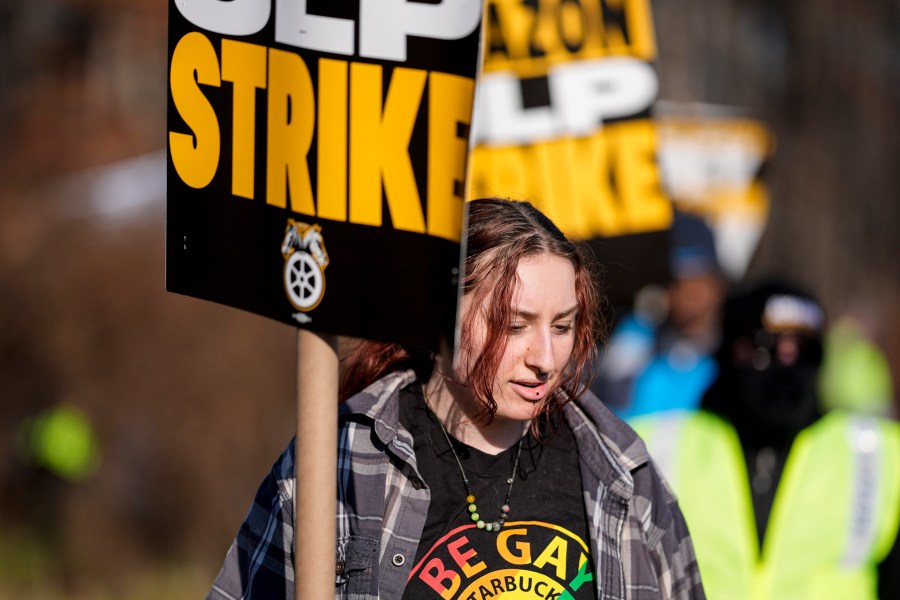 A pro-union demonstrator marches outside an Amazon warehouse, Friday, Dec. 20, 2024, in Alpharetta, Ga. (AP Photo/Mike Stewart)