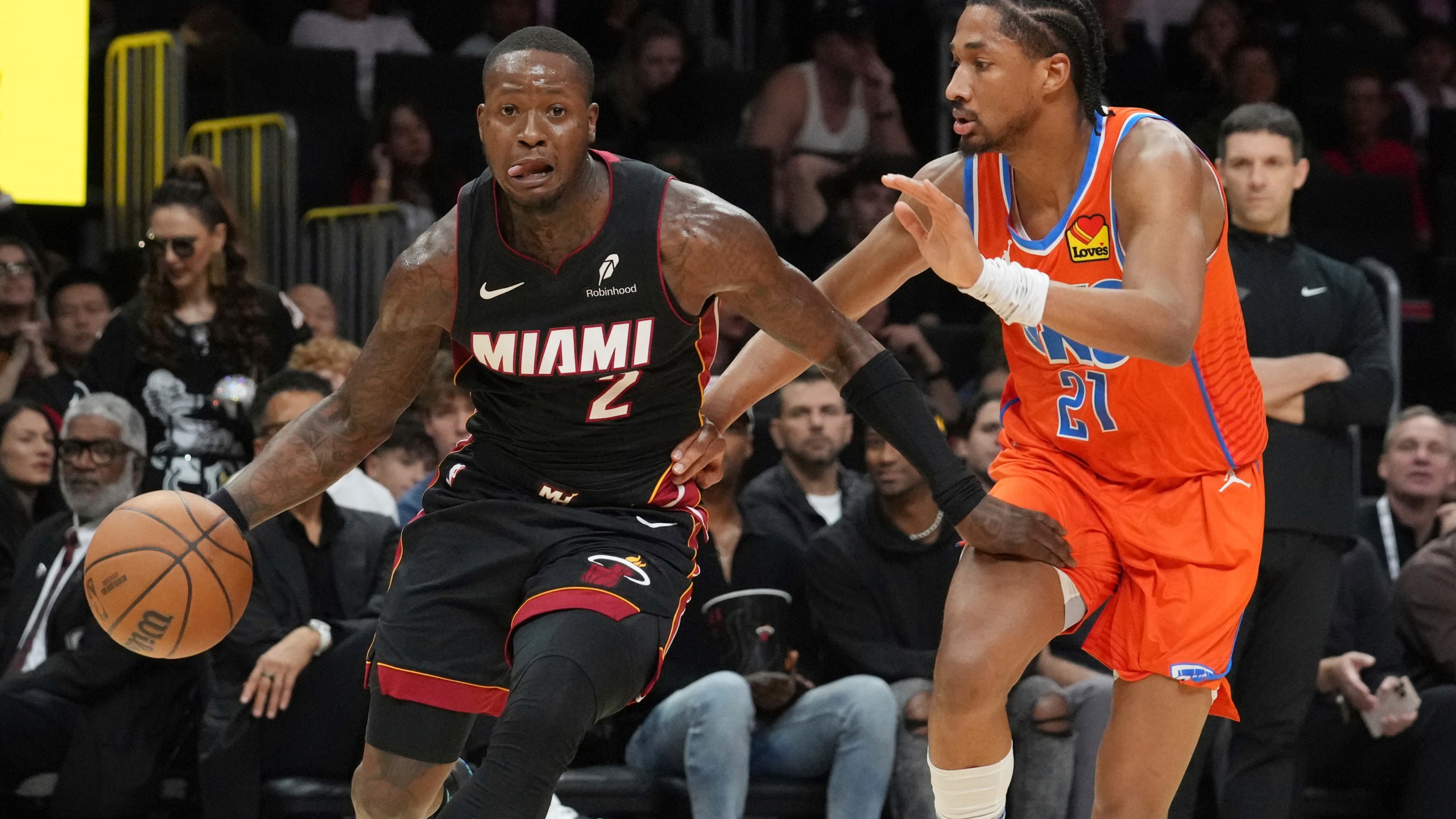 Oklahoma City Thunder guard Aaron Wiggins (21) defends Miami Heat guard Terry Rozier (2) during the first half of an NBA basketball game, Friday, Dec. 20, 2024, in Miami. (AP Photo/Marta Lavandier)