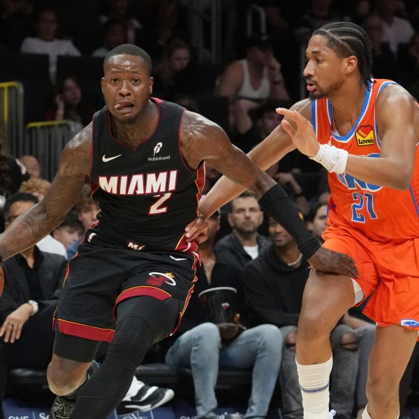 Oklahoma City Thunder guard Aaron Wiggins (21) defends Miami Heat guard Terry Rozier (2) during the first half of an NBA basketball game, Friday, Dec. 20, 2024, in Miami. (AP Photo/Marta Lavandier)