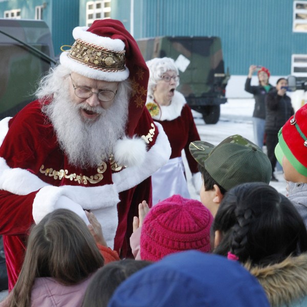 Santa Claus meets children after arriving at the school in Yakutat, Alaska, as part of the Alaska National Guard's Operation Santa initiative that brings Christmas to an Indigenous community that has suffered a hardship, Wednesday, Dec. 18, 2024. (AP Photo/Mark Thiessen).