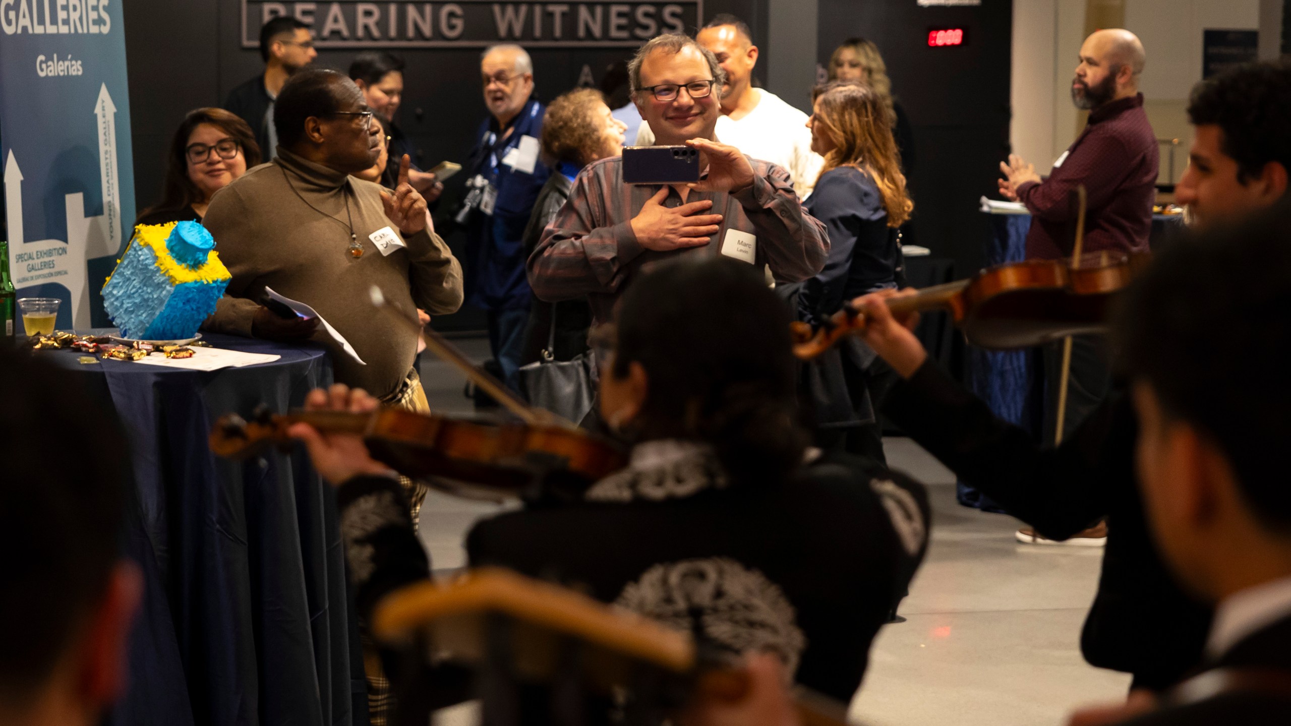 Guests enjoy a performance by Mariachi Palmeros during a Chicanukah event at Holocaust Museum Houston on Thursday, Dec. 19, 2024, in Houston. (AP Photo/Annie Mulligan)