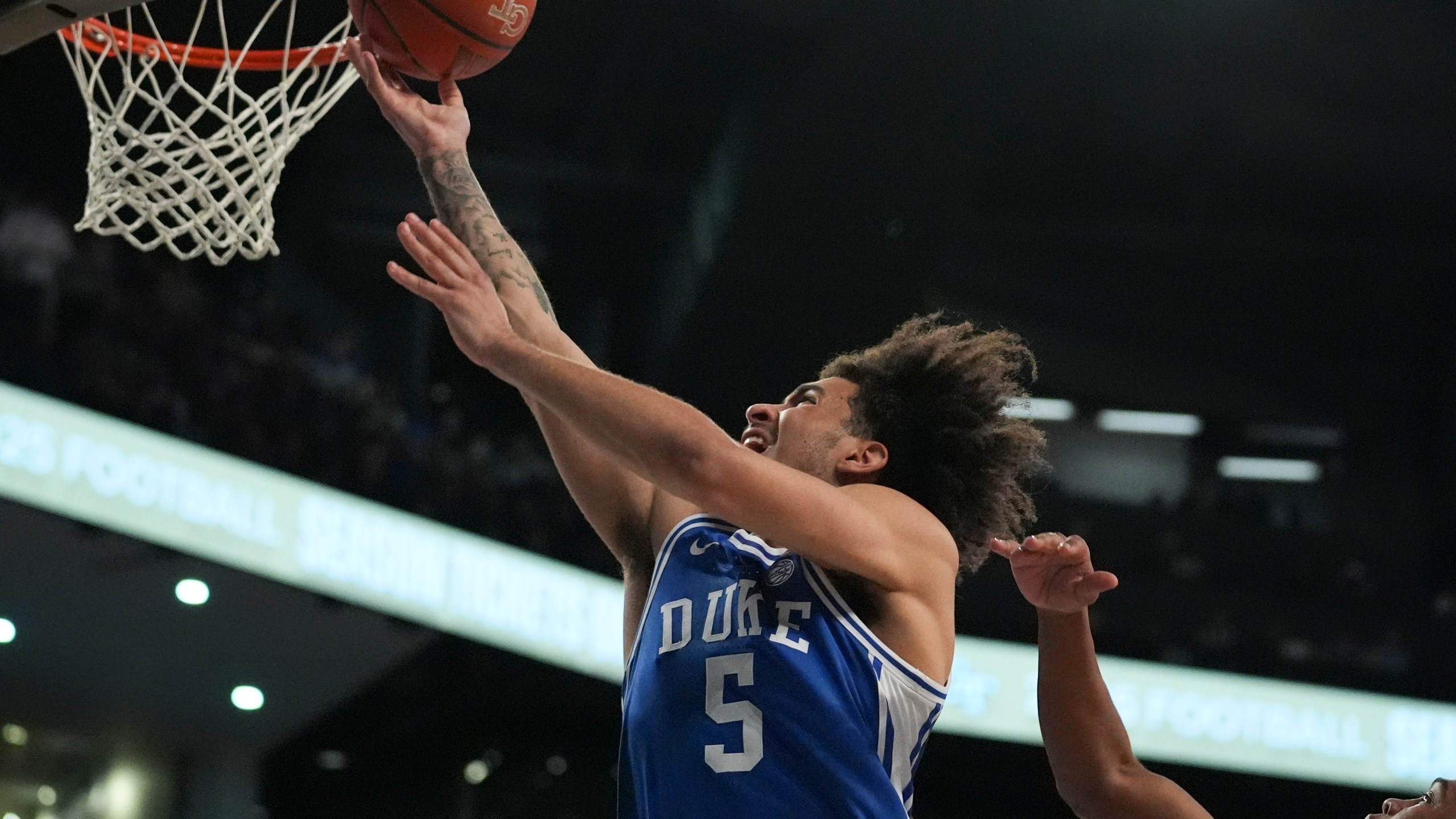 Duke guard Tyrese Proctor (5) is fouled by Georgia Tech guard Javian McCollum (2) during the first half of an NCAA college basketball game on Saturday, Dec. 21, 2024 in Atlanta. (AP Photo/Brynn Anderson)