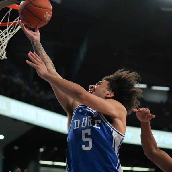 Duke guard Tyrese Proctor (5) is fouled by Georgia Tech guard Javian McCollum (2) during the first half of an NCAA college basketball game on Saturday, Dec. 21, 2024 in Atlanta. (AP Photo/Brynn Anderson)