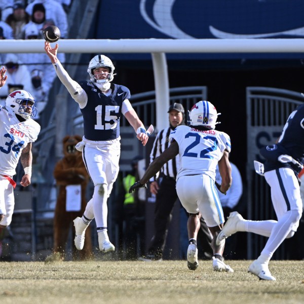 Penn State quarterback Drew Allar throws a pass to wide receiver Harrison Wallace III as SMU safety Cale Sanders Jr. (22) defends during the first half in the first round of the NCAA College Football Playoff, Saturday, Dec. 21, 2024, in State College, Pa. (AP Photo/Barry Reeger)