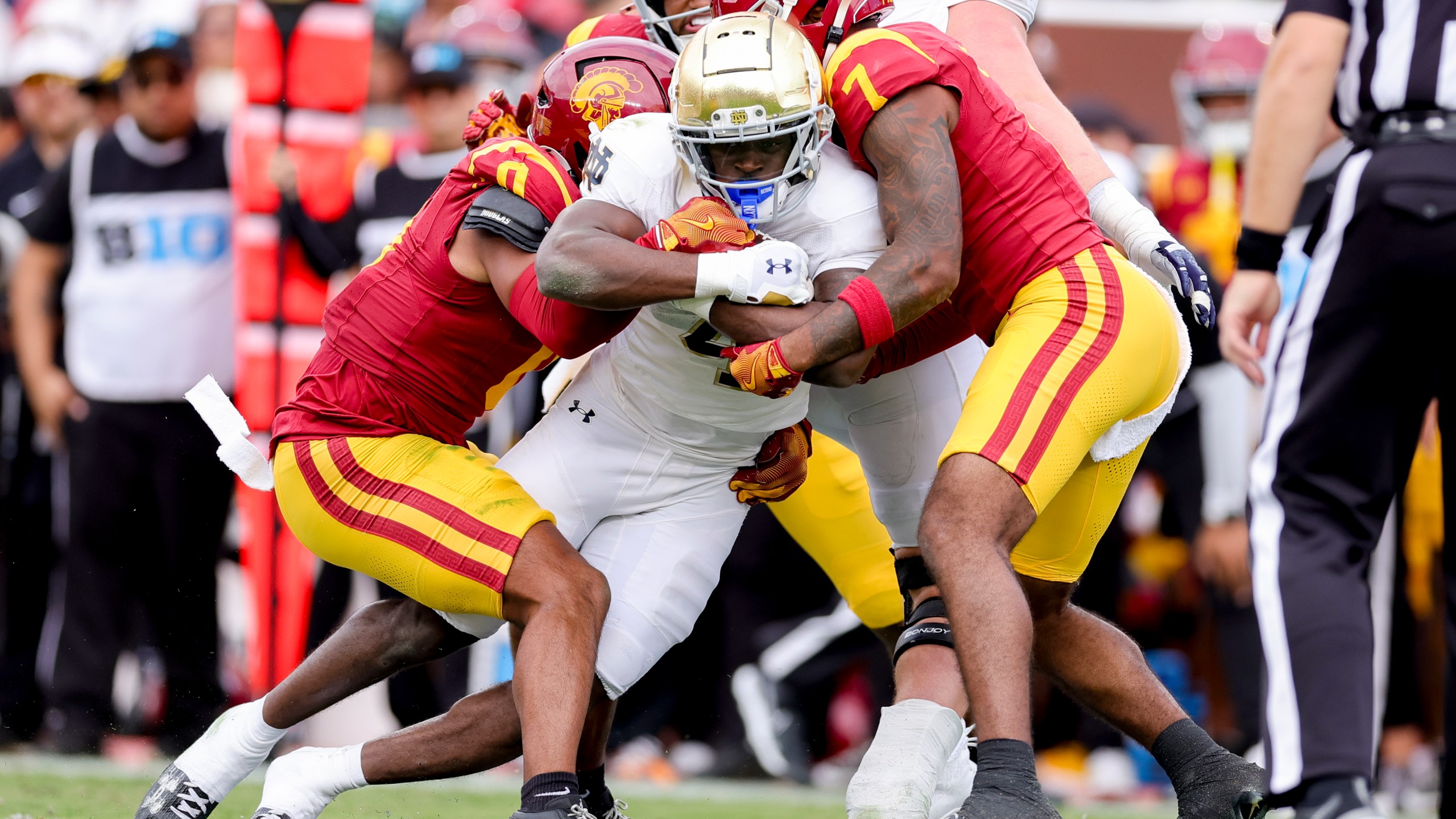 Notre Dame running back Jeremiyah Love, center, is tackled by Southern California safetys Akili Arnold, left, and Kamari Ramsey during the first half of an NCAA college football game against Southern California, Saturday, Nov. 30, 2024, in Los Angeles. (AP Photo/Ryan Sun)