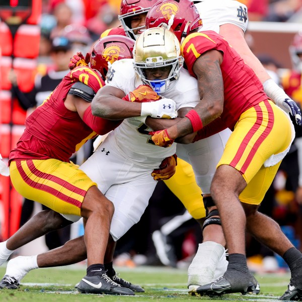 Notre Dame running back Jeremiyah Love, center, is tackled by Southern California safetys Akili Arnold, left, and Kamari Ramsey during the first half of an NCAA college football game against Southern California, Saturday, Nov. 30, 2024, in Los Angeles. (AP Photo/Ryan Sun)