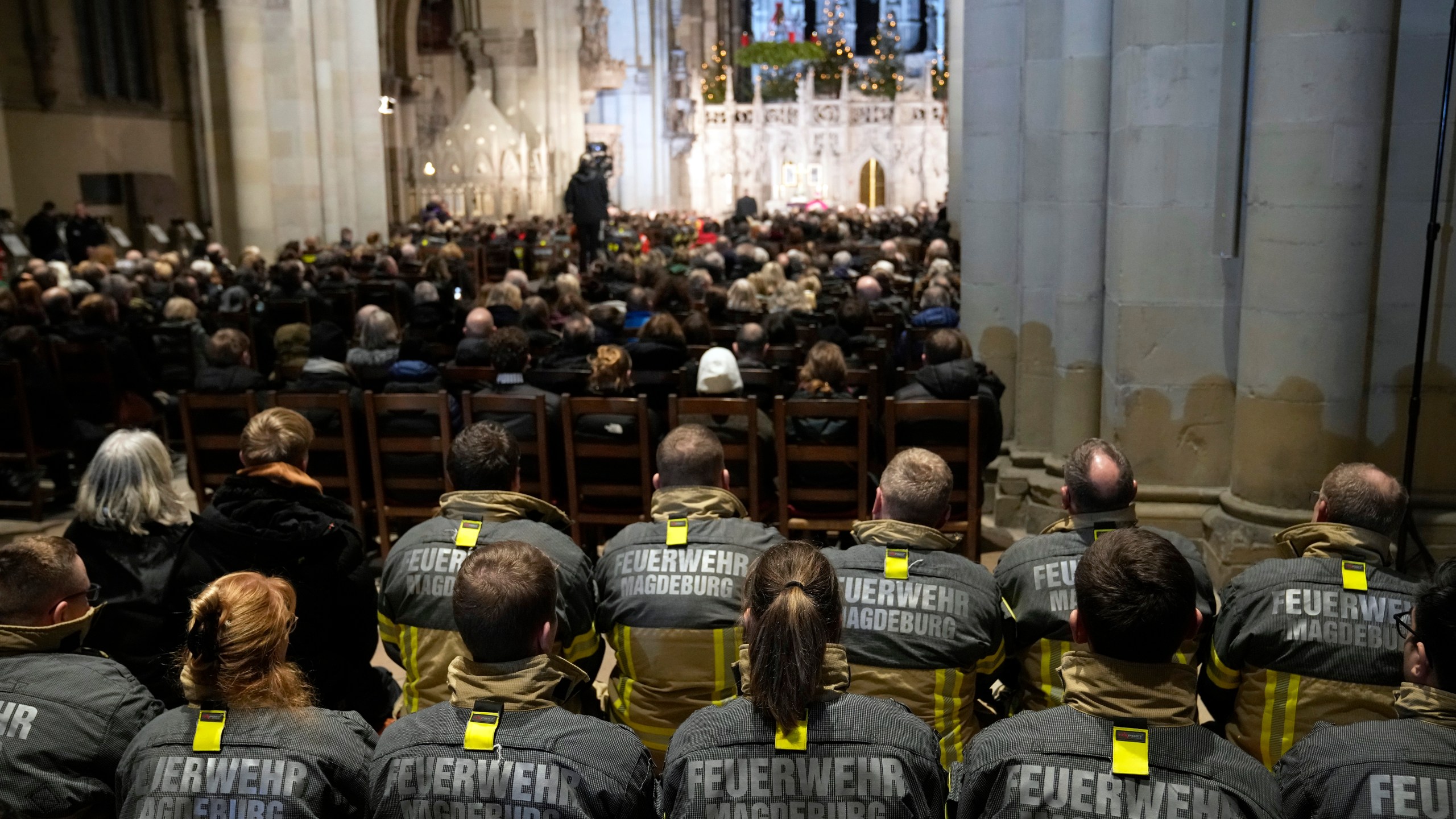 Firefighters, in the foreground, and others, attend a memorial service for victims of Friday's Christmas Market attack, where a car drove into a crowd, in Magdeburg, Germany, Saturday, Dec. 21, 2024. (AP Photo/Ebrahim Noroozi)